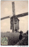 (homme avec canne sur chemin près d'un moulin à vent (gros plan))