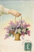 Panier de fleurs de lilla tenu par une main féminine