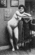 Femme nue de face accoudée à une table haute