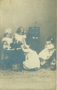 Quatre fillettes jouant à la poupée