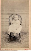 Bébé assis sur un fauteuil en osier Bébé assis sur un fauteuil en osier