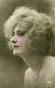 (Jeune femme en buste et collier de perles, cheveux châtains mi longs)