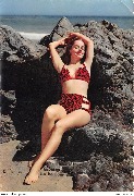 Pin-up assise sur les rochers les bras en l'air